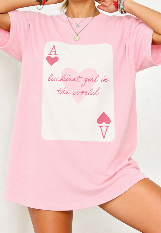 Pink t-shirt with a graphic design and text on a plain background